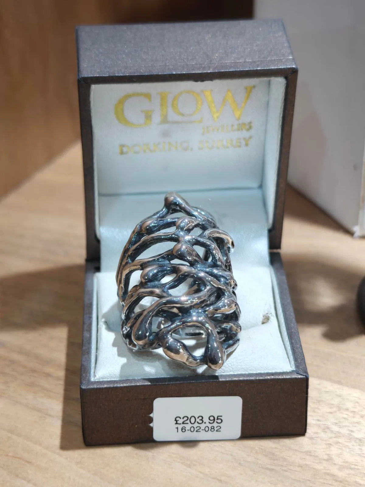 A silver cluster ring in a Glow Jewellers box