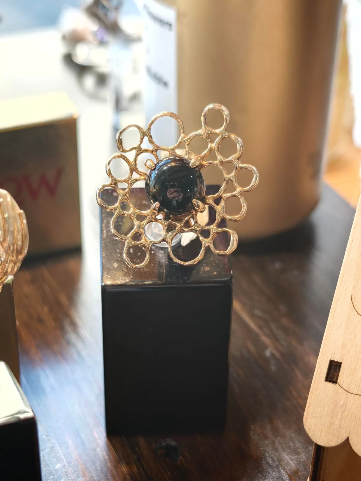 A gold openwork flower brooch with a dark centre stone