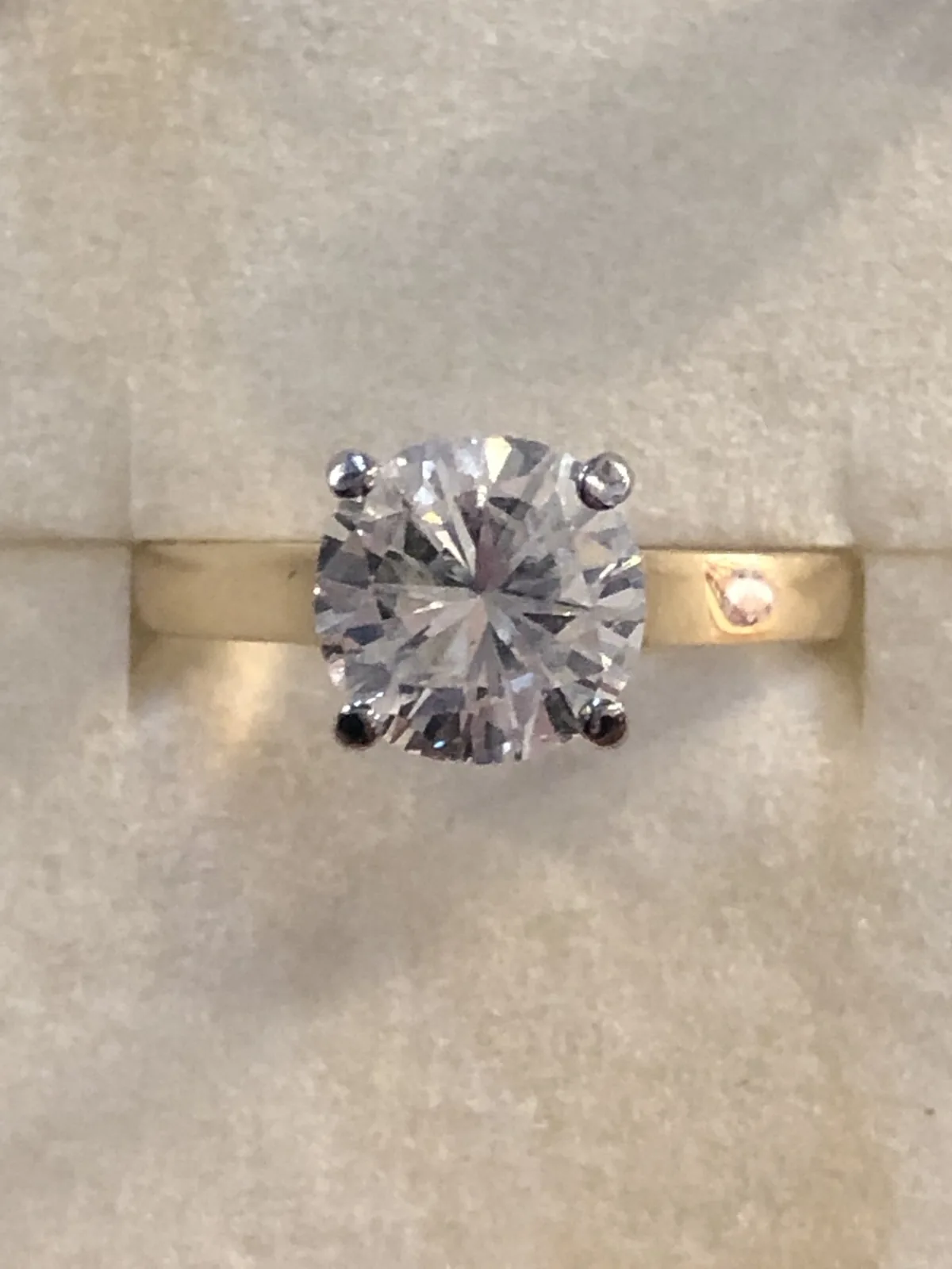A round diamond solitaire ring in yellow gold, set in its box